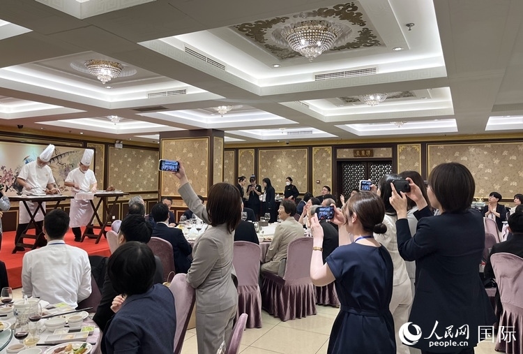 國家級非物質(zhì)文化遺產(chǎn)、全聚德片鴨工藝吸引代表團(tuán)成員拍照留念。