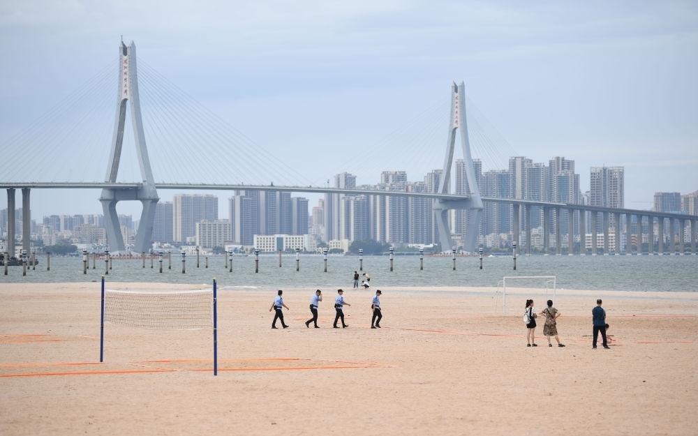 2023年7月17日，廣東湛江五環(huán)廣場(chǎng)的沙灘上，公安民警在執(zhí)勤巡邏。新華社記者 鄧華 攝