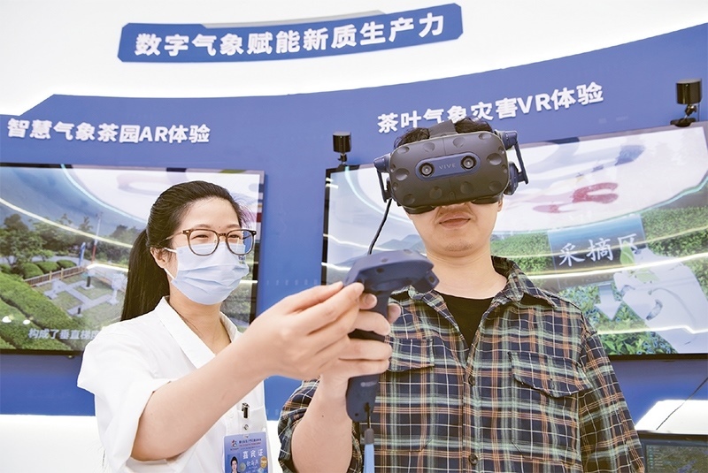 2024年5月23日，第七屆數(shù)字中國建設(shè)峰會現(xiàn)場體驗區(qū)在福州海峽國際會展中心向?qū)I(yè)觀眾開放。本次現(xiàn)場體驗區(qū)圍繞本屆峰會主題“釋放數(shù)據(jù)要素價值，發(fā)展新質(zhì)生產(chǎn)力”，設(shè)置“數(shù)字惠民”、“數(shù)字能力”、“數(shù)字基礎(chǔ)”、“數(shù)字生態(tài)”、“數(shù)字賦能”五大板塊。圖為一名觀眾（右）在數(shù)字氣象賦能新質(zhì)生產(chǎn)力展臺上進行體驗。 新華社記者 魏培全/攝