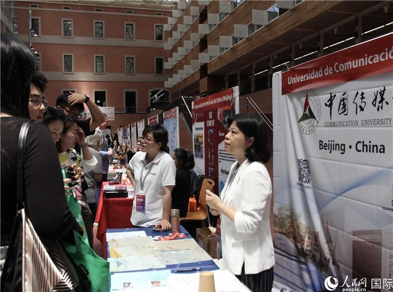 旅西華人華僑在展臺前咨詢。人民網(wǎng)記者 許海林攝