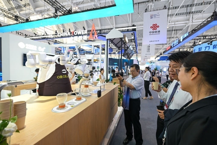 6月20日，與會(huì)者品嘗機(jī)器人沖調(diào)出的咖啡。新華社記者 孫凡越 攝