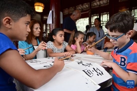 7月4日，在馬耳他桑塔露琪亞市的中國(guó)古典園林“靜園”，人們體驗(yàn)中國(guó)書法。新華社發(fā)（喬納森·博格 攝）