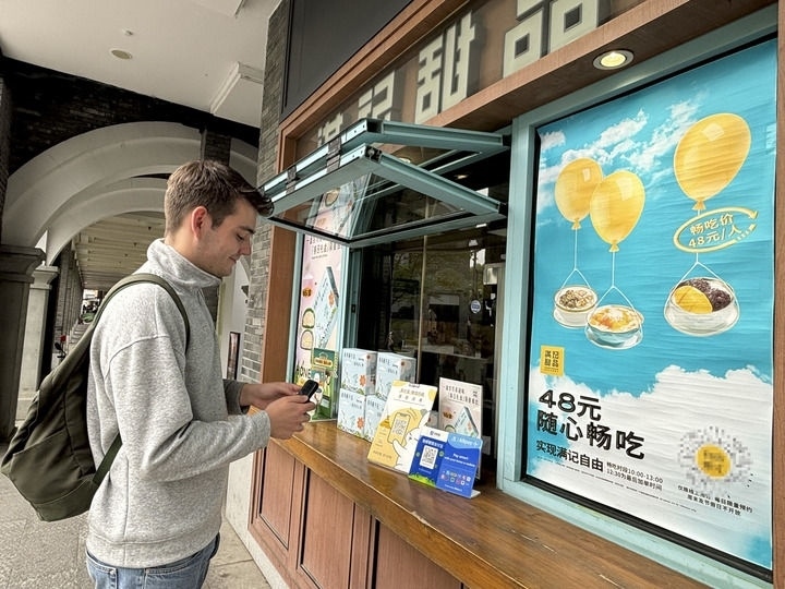 來自德國的留學生理查德在杭州西湖邊一家商鋪使用支付寶掃碼支付（2024年4月11日攝）。新華社發(fā)