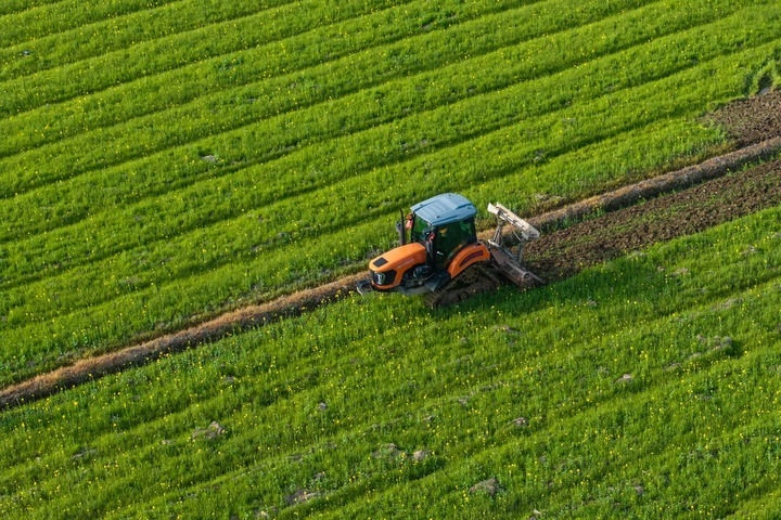 2024年3月19日，在湖南省常德市鼎城區(qū)謝家鋪鎮(zhèn)港中坪村，村民駕駛農(nóng)機翻耕田地（無人機照片）。新華社記者 陳思汗 攝