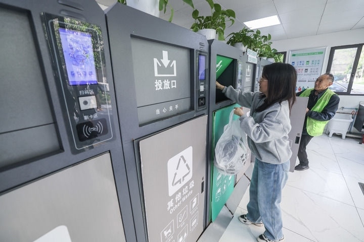 2024年4月10日，在浙江省湖州市吳興區(qū)飛英街道新華府小區(qū)內(nèi)，居民在垃圾分類智能系統(tǒng)的指導下進行垃圾分類投放，居民的投放情況將實時匯總到智慧服務平臺，會有相應的積分獎勵。新華社記者 徐昱 攝