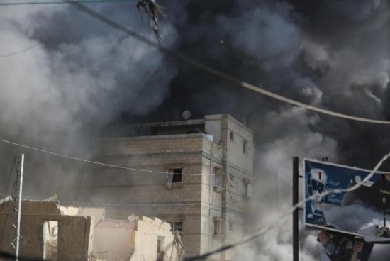 7月21日，在加沙地帶中部的努賽賴特難民營(yíng)，遭以軍空襲的建筑冒出滾滾濃煙。新華社發(fā)（馬爾萬(wàn)·達(dá)烏德攝）