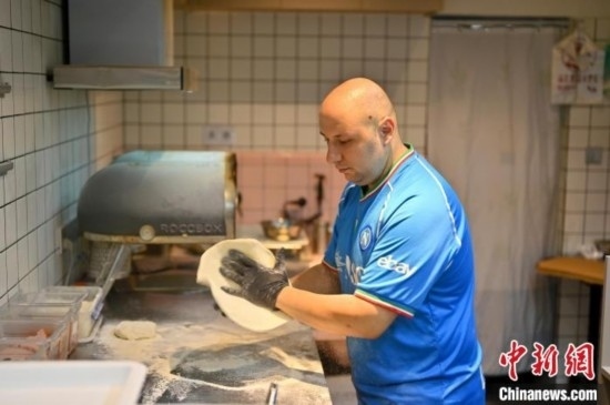 近日，韋榮耀在自家披薩小店內(nèi)忙活。俞靖 攝