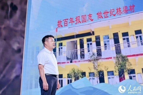 張玉滾分享用一根扁擔(dān)送孩子們走出大山的故事。人民網(wǎng)攝