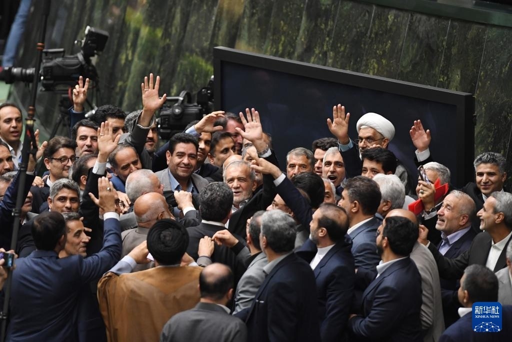 7月30日，在伊朗德黑蘭的伊朗議會(huì)，佩澤希齊揚(yáng)（中）離開(kāi)總統(tǒng)就職典禮現(xiàn)場(chǎng)時(shí)揮手致意。新華社記者 沙達(dá)提 攝