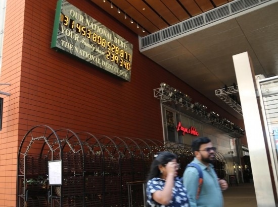 2023年5月29日，人們經(jīng)過美國紐約曼哈頓的“國債鐘”?！皣鴤姟笔且粋€大型計數(shù)器，它實時更新美國的公共債務總額，并顯示出每個美國家庭所要負擔的數(shù)額。 新華社記者劉亞南攝