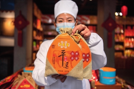 在位于山西省晉中市平遙縣的平遙古城南大街的一家平遙牛肉店內(nèi)，工作人員展示一款牛肉產(chǎn)品（資料照片）楊晨光攝 / 本刊