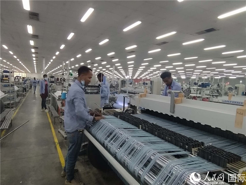 無(wú)錫金茂埃塞面料廠車間內(nèi)，當(dāng)?shù)毓と苏谝唤z不茍地作業(yè)。人民網(wǎng)記者 黃培昭攝