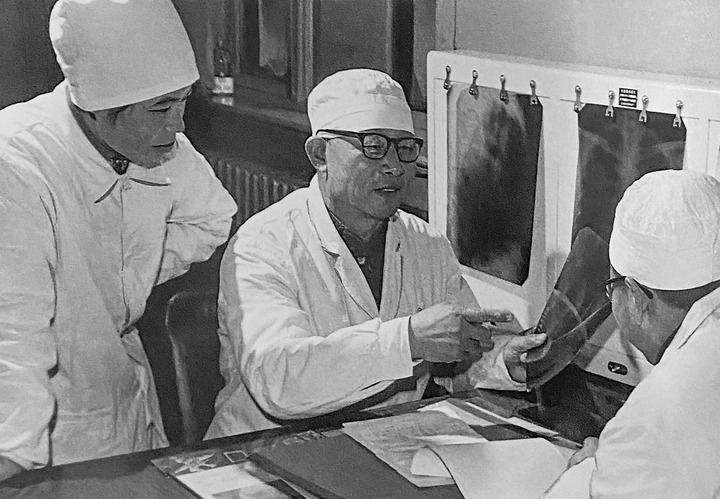 1980年1月16日，中日友好醫(yī)院首任院長辛育齡（中）在內(nèi)蒙古結(jié)核病院與胸外科醫(yī)師討論病例（翻拍照片）。 新華社發(fā)