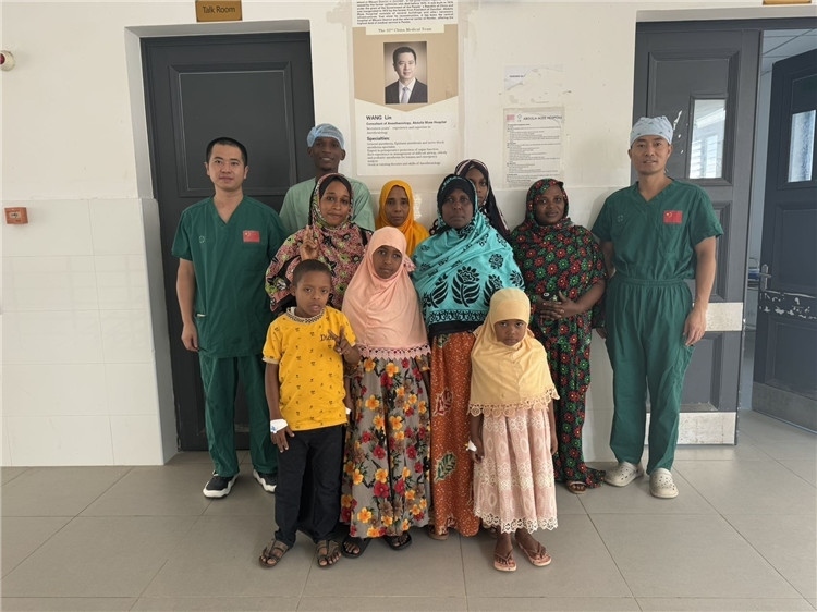 李廣（右一）和王林醫(yī)生與部分患者合影。中國援桑醫(yī)療隊供圖