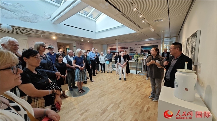 參展人、景德鎮(zhèn)陶瓷大學美術學院副院長邵長宗（右一）向來賓介紹參展作品。人民網(wǎng)記者 殷淼攝