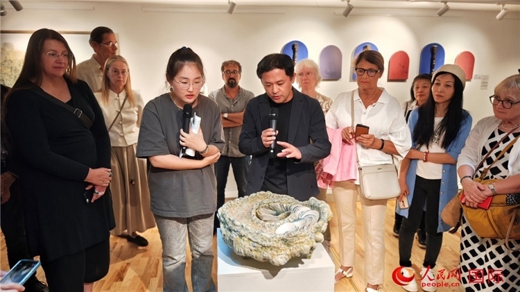 參展人、景德鎮(zhèn)陶瓷大學設計藝術學院副院長余劍峰（中）向來賓介紹參展作品。人民網(wǎng)記者 殷淼攝
