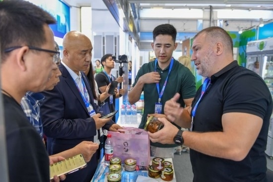 2023年8月23日，在第十四屆中國(guó)—東北亞博覽會(huì)東北亞商品館，俄羅斯參展商向參觀者介紹商品。