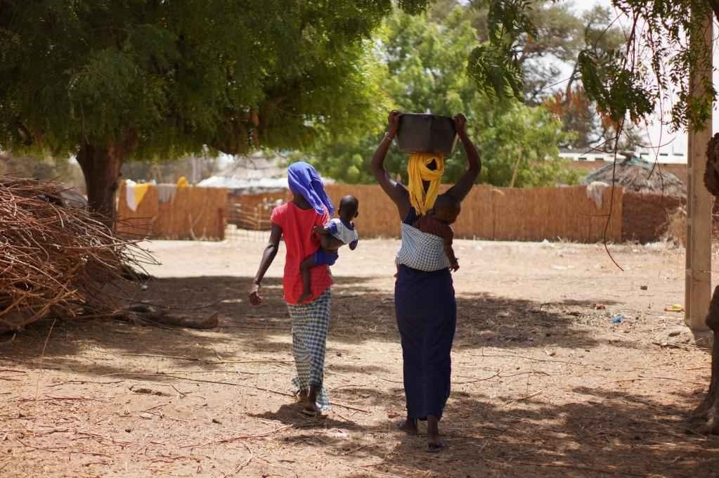 2023年3月20日，在塞內(nèi)加爾久爾貝勒區(qū)的泰內(nèi)富勒村，村民將取到的水運(yùn)回家。新華社記者 王子正 攝