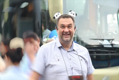 參訪熊貓谷前，塞爾維亞“一帶一路”研究所所長博揚·拉利奇戴上熊貓頭飾。（李佩藺 攝）