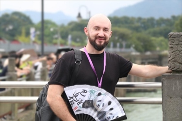 俄羅斯塔斯社執(zhí)行編輯葉夫根尼·扎多羅日內在都江堰魚嘴拍照留念。（李佩藺 攝）