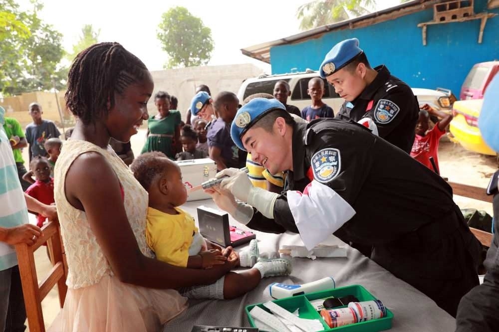 2017年12月28日，在利比里亞蒙羅維亞，中國(guó)維和警察防暴隊(duì)醫(yī)療人員為兒童做口腔檢查。