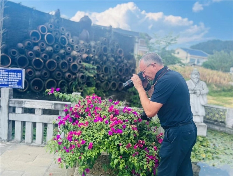 遠(yuǎn)處黔北民居錯(cuò)落有致，近處一只黑色的蝴蝶穿梭于粉紫色三角梅花叢間隙，與俄羅斯“大歐亞”總編輯弗拉基米爾·別列日內(nèi)赫的鏡頭玩起了捉迷藏，“你追我逃，不亦樂(lè)乎”。（張亞欣攝）