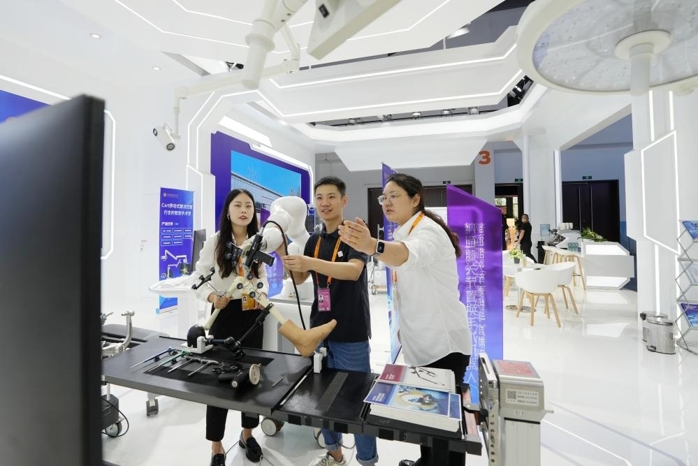 9月11日，一位媒體記者（中）在2024年服貿(mào)會(huì)國(guó)家會(huì)議中心會(huì)場(chǎng)體驗(yàn)北京納通科技集團(tuán)有限公司的膝關(guān)節(jié)置換手術(shù)機(jī)器人。新華社記者鞠煥宗 攝