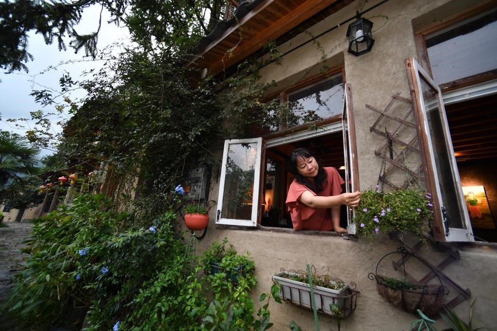 8月29日，在福建省屏南縣熙嶺鄉(xiāng)，龍?zhí)洞濉靶麓迕瘛泵泛暝诖蚶碜约航?jīng)營(yíng)的民宿外墻裝飾花盆。新華社記者姜克紅 攝