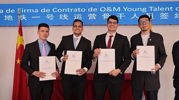 當?shù)貢r間9月13日，40名哥倫比亞青年與中企承建運營的波哥大地鐵一號線項目簽約，不久將前往中國進行為期15個月的專業(yè)地鐵知識培訓。圖為部分學員在簽約儀式上展示所簽的協(xié)議。 波哥大地鐵一號線項目供圖