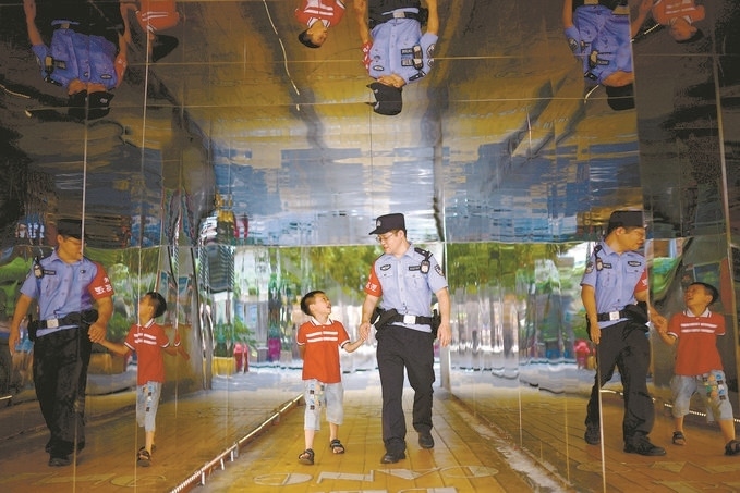 ?7月16日，重慶市公安局江北區(qū)分局一名民警在巡邏途中遇到一個獨自玩耍的小男孩，民警將其送回家。王洪平攝