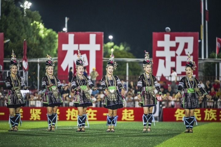 2024年9月28日，榕江縣侗族大歌隊(duì)的演員們?cè)凇按宄弊闱驁?chǎng)上表演。當(dāng)日，“發(fā)現(xiàn)中國之美·相約貴州村超”國際友誼賽在貴州省黔東南苗族侗族自治州榕江縣的“村超”足球場(chǎng)舉行。新華社記者 陶亮 攝