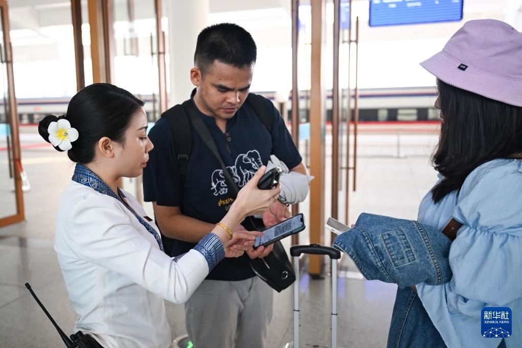 10月12日，在老撾萬象中老鐵路萬象站，工作人員檢驗乘客車票。新華社記者 程一恒 攝