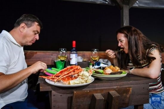9月2日，食客們在俄羅斯符拉迪沃斯托克的一家餐館品嘗帝王蟹。新華社記者 曹陽 攝