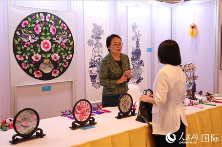 青海非遺文化傳承人向嘉賓介紹展品。人民網實習生姚欣可攝