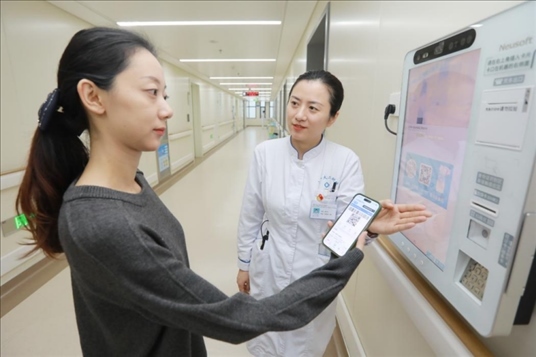 醫(yī)護(hù)人員引導(dǎo)患者在自助機(jī)前辦理自助入院手續(xù)。圖片來源：山東第一醫(yī)科大學(xué)第二附屬醫(yī)院