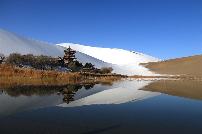 鳴沙山月牙泉景區(qū)雪景。敦煌市委宣傳部供圖，張曉亮攝