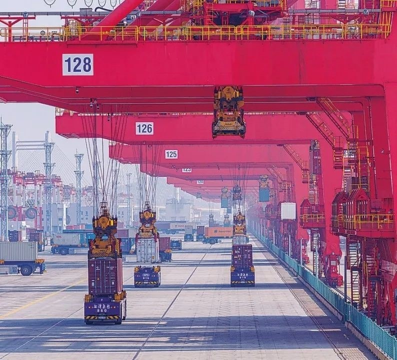 共建“一帶一路”國家在工作制度對接、技術標準協調、檢驗結果互認等方面強化合作、統(tǒng)一標準，貿易自由化便利化水平不斷提升。上海洋山港海關對接共建國家進出口貨物相關標準，推動通關一體化方式申報，提升通關效率。圖為無人駕駛的全自動導引車在洋山港穿梭往來，搬運集裝箱。王初 攝