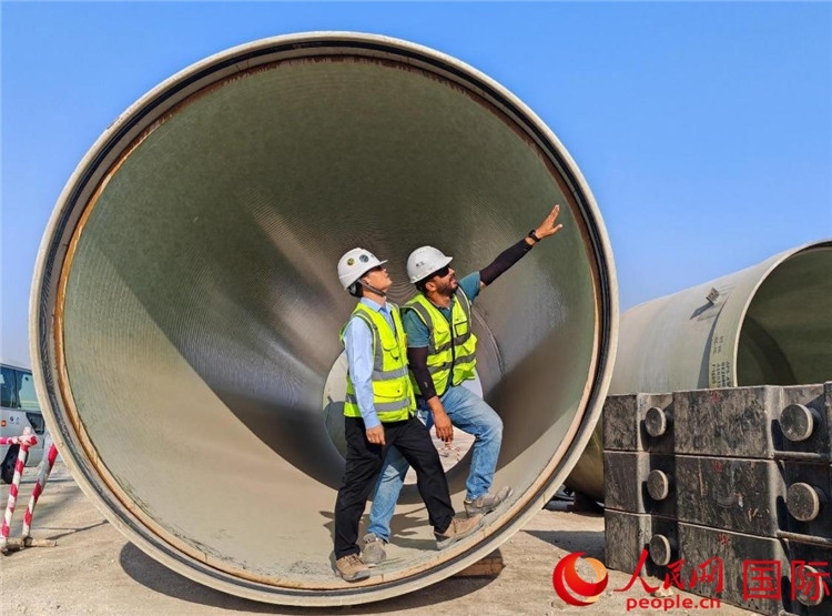工作人員在察看輸水管情況。人民網(wǎng)記者 管克江攝