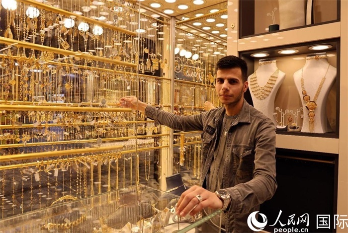 一名銷售員展示黃金飾品。人民網(wǎng) 伊納斯·易卜拉欣攝