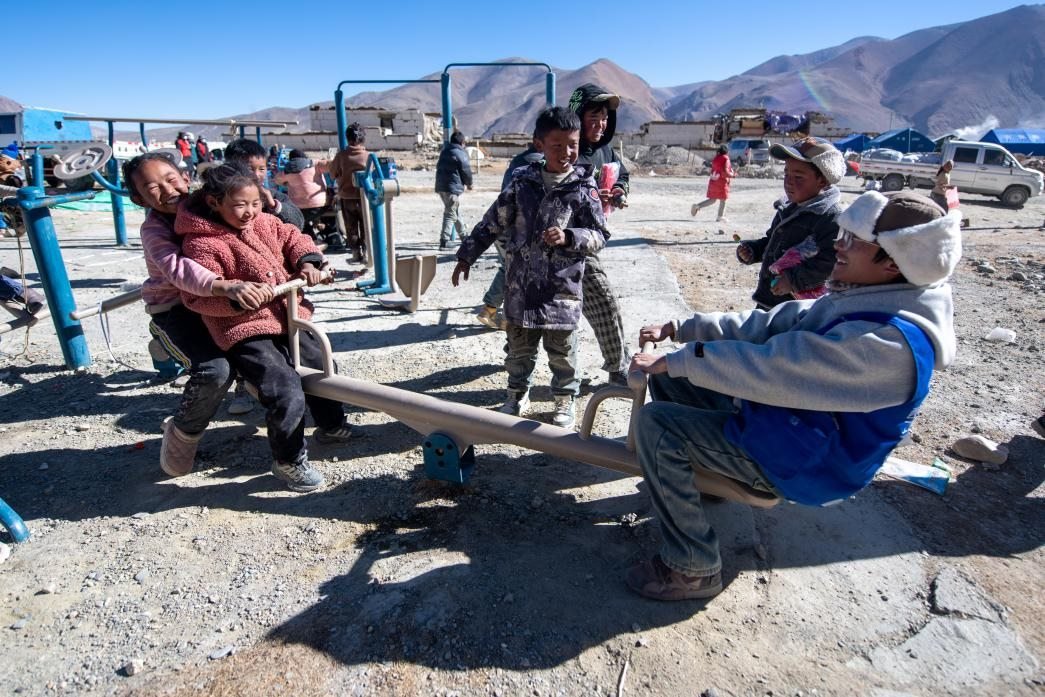 1月11日，在定日縣措果鄉(xiāng)塘仁村安置點(diǎn)，西藏星光社會(huì)工作服務(wù)中心志愿者和孩子們一起玩耍，進(jìn)行災(zāi)后心理疏導(dǎo)。人民網(wǎng)記者 翁奇羽攝