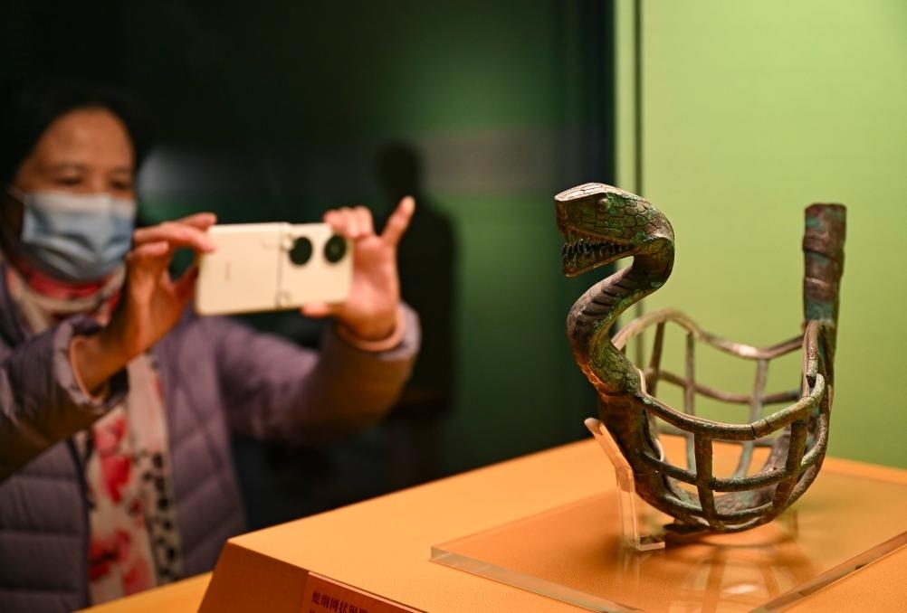 1月14日，觀(guān)眾在上海博物館蛇年迎春展拍攝展品蛇綱網(wǎng)狀銅器。新華社發(fā)（陳浩明攝）