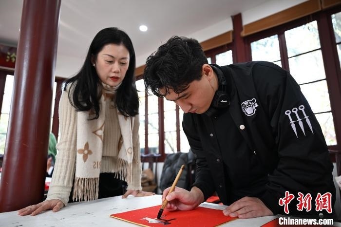 1月20日，外籍留學(xué)生在西泠印社社員李硯指導(dǎo)下寫福。當(dāng)日，來自巴西、馬來西亞、加納、哈薩克斯坦的外籍留學(xué)生在浙江杭州西泠印社體驗福貼、春聯(lián)和篆刻，感受古老的中國傳統(tǒng)文化。中新社記者 王剛 攝
