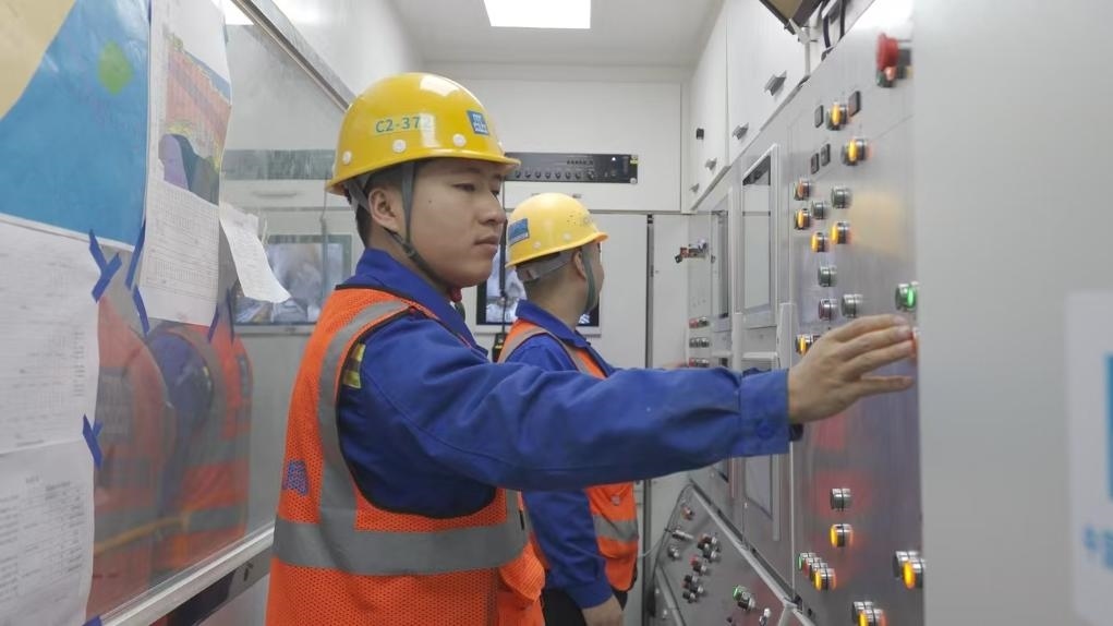 盾構(gòu)司機(jī)何曉波在駕駛室內(nèi)調(diào)試盾構(gòu)機(jī)參數(shù)。（劉芬攝）