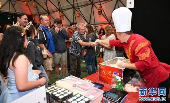 圖為游客在燈節(jié)現場購買小吃。（圖片由奧克蘭中國文化中心提供）
