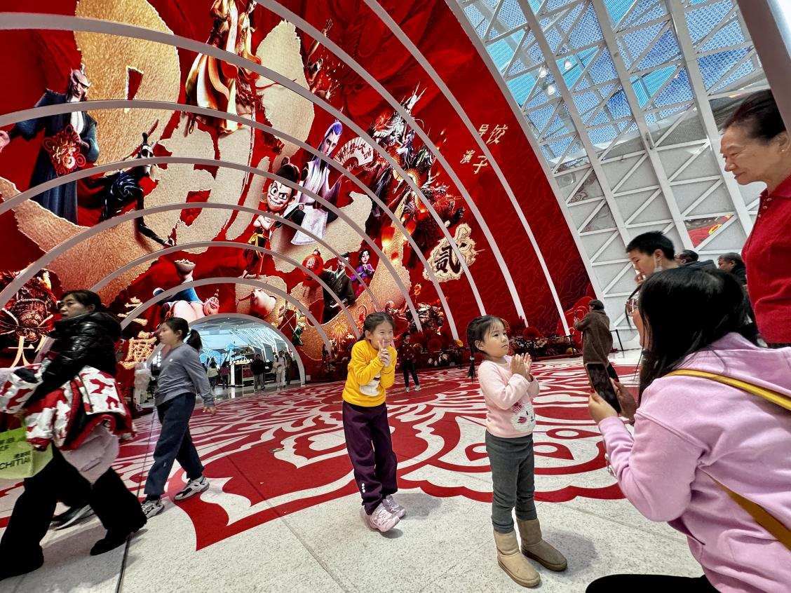 乙巳蛇年春節(jié)期間，影迷在《哪吒之魔童鬧海》巨幅海報前拍照打卡。