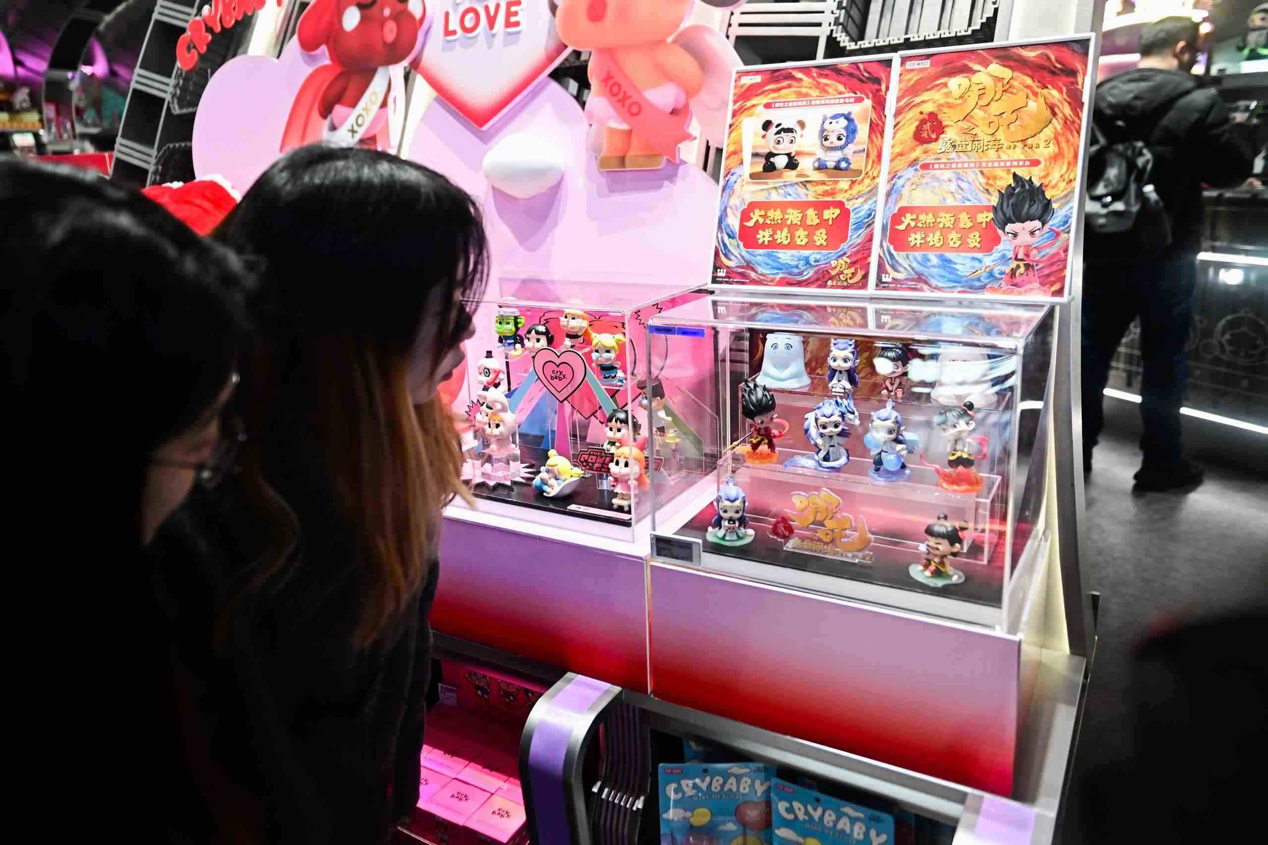 △2025年2月22日，上海，市民在圍觀《哪吒之魔童鬧?！废嚓P(guān)手辦盲盒。