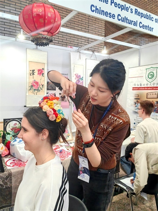 展覽正值羅馬尼亞迎春花節(jié)，國際中文教師志愿者潘婧穎向游客們介紹了國家非物質(zhì)文化遺產(chǎn)——福建泉州的簪花文化。布加勒斯特大學(xué)孔子學(xué)院供圖。