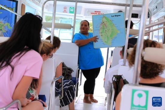 3月15日，一名導游在游艇上為游客介紹塞舌爾拉迪格島。新華社記者 董江輝 攝