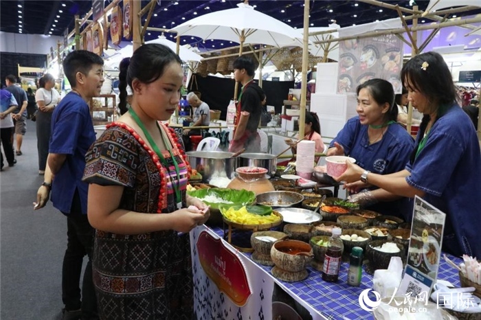 游客在攤位前購買特色美食。朱瀟逸攝