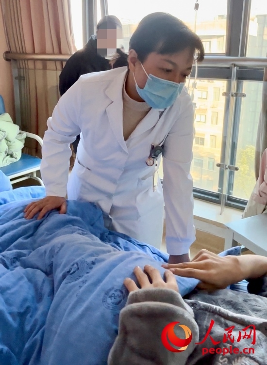 鄧茜查房時(shí)詢問(wèn)患者情況。人民網(wǎng)記者 金慧慧攝